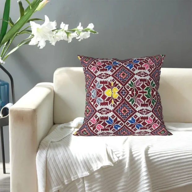 Housse de coussin Tatreez posée sur un fauteuil clair