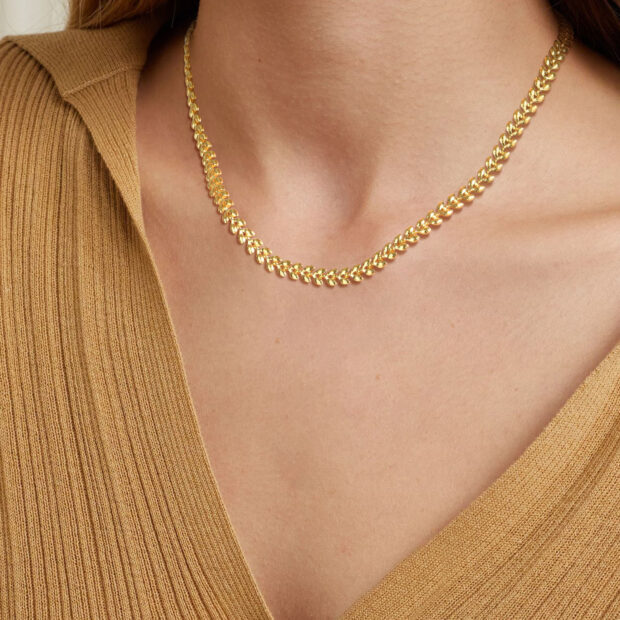 Collier doré à chaîne de feuilles d’olivier porté autour du cou