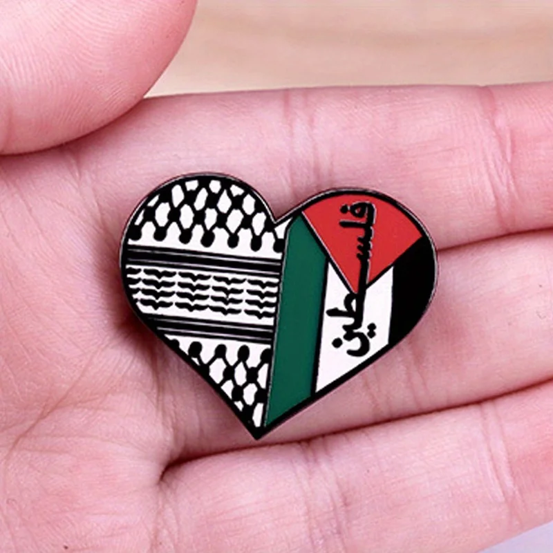 Broche cœur Palestine et keffieh montrée dans une main
